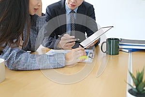 Two businesspeople working with digital tablet and discussing a new project at office.