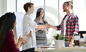 Two businesspersons shaking hands in agreement with congratulating