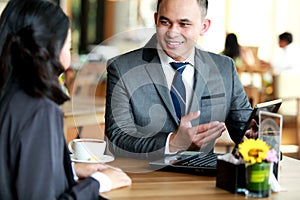 Two businesss people talking about planning work at cafe