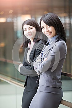 Two businesswoman smile to you