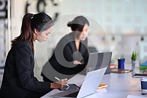 Two businesswoman working and planning a strategy in office.