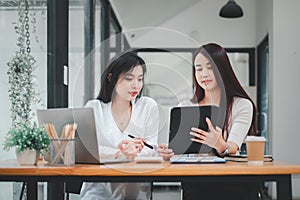 Two businesswoman working together on digital tablet.