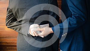 Two businesswomen shaking hands while one man giving money and receive cash.  corruption concept