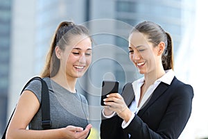 Two businesswomen talking about smart phone photo
