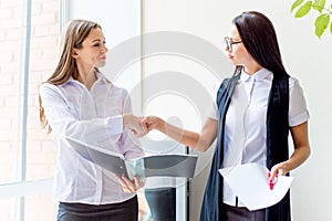 Two businesswomen telling gossip in an office