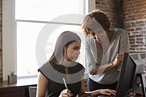 Two Businesswomen Working On Computer In Office