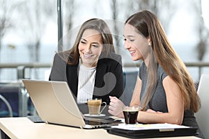 Two businesswomen working on line in a bar