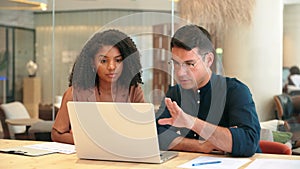 Two busy business man and woman working on laptop discussing project at work.