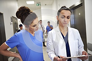 Two busy doctors discussing some medical records