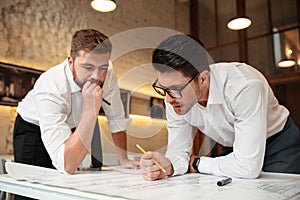Two busy pensive businessmen working on a business plan