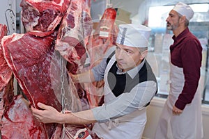 Two butchers checking meat stocks