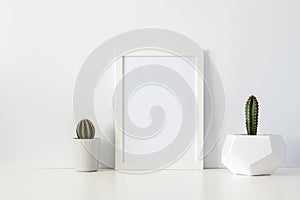 Two cactuses in pots against a white empty wall. Mockup frame.