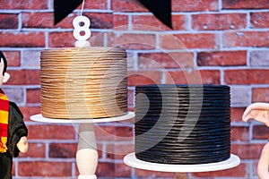 two cakes with a figure of harry potter and a birthday hat