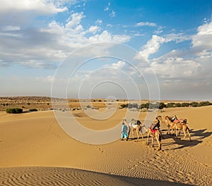 Two cameleers (camel drivers) with camels in dunes of Thar deser