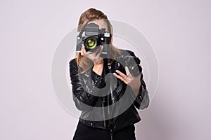 Two cameras. Young girl photographer. White background. Black cl