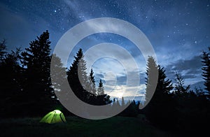 Two camp tents in forest under beautiful night sky.