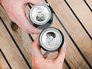 Two can of beer, female and male hands