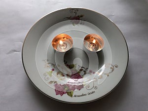 Two candles burn on a plate