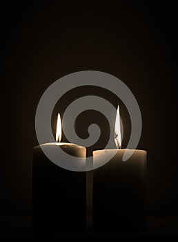 Two candles burning in dark