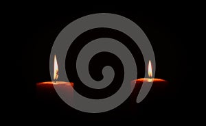Two candles burning in dark