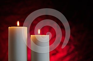 Two candles with red background