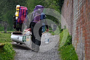 Two canoeists carry their canoe towards Caen Hill Flight