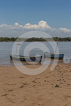 Two canoes moored on the river bank