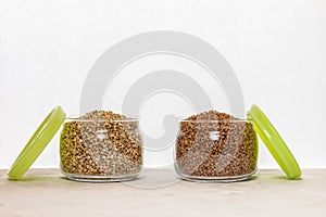 Two cans of green and brown buckwheat on white background.