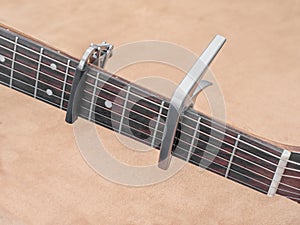two Capo on the Acoustic guitar neck , capro made from aluminium, Selective focus at capo