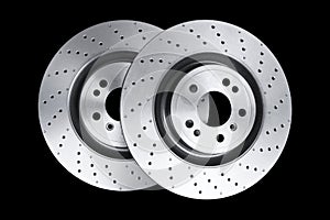 Two car brake disc isolated on black background. Auto spare parts. Perforated brake disc rotor isolated on black. Braking
