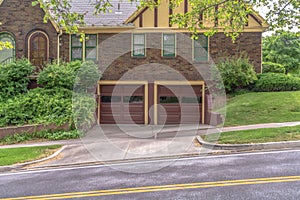 Two car garage with glass panes on door of a house with brick exterior wall