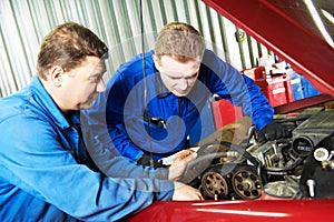 Two car mechanic diagnosing auto engine problem