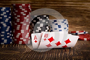 Two cards and poker chips on wooden background
