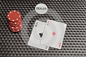 Two cards with red poker chips and the dealer chip