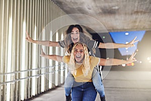 Two carefree friends having fun in the city at night