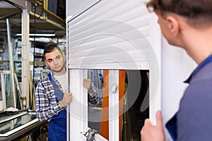 Two careful workmen inspecting windows