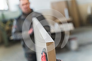 two carpenters holding a big wooden plank at the workshop, wood manufacture concept