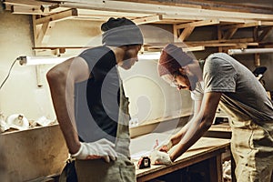Two carpenters making sketches on workbench
