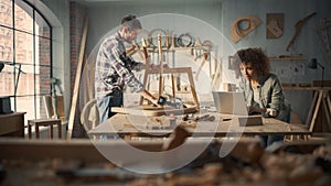 Two Carpenters Working Together in a Woodwork Workshop. Multicultural Man and Female Colleagues