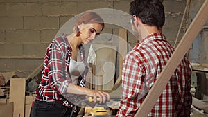 Two carpenters working on wood plank at the workshop