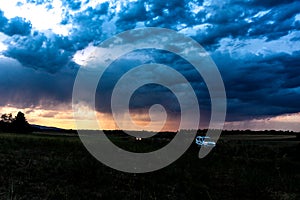 Two cars at dusk crossing the fields