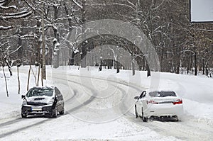 Two cars moving the opposite lanes on the slippery icy road