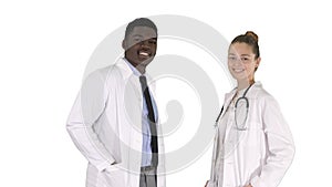 Two caucasian and afro american smiling doctors standing looking