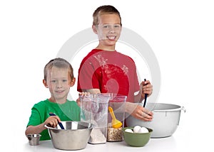 Two caucasian brothers baking a cake