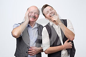 Two caucasian men laughing on his friends joke