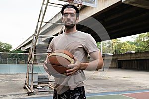 Two caucasian men pratice baskegball in court at urban street