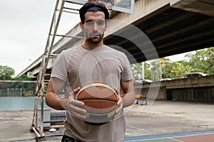 Two caucasian men pratice baskegball in court at urban street