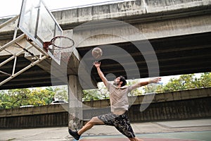 Two caucasian men pratice baskegball in court at urban street