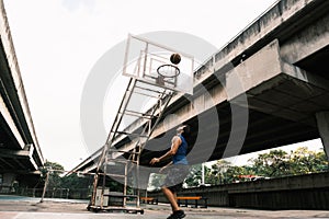 Two caucasian men pratice baskegball in court at urban street