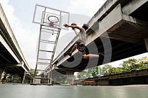 Two caucasian men pratice baskegball in court at urban street